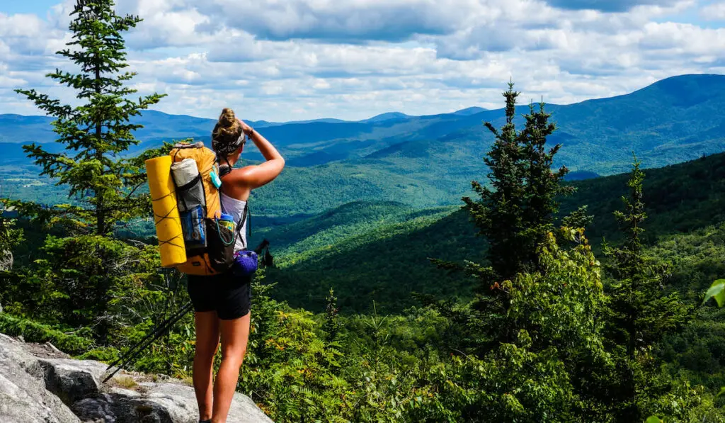  An Appalachian Trail Thru-Hiker looks back at New Hampshire just before she crosses into Maine,