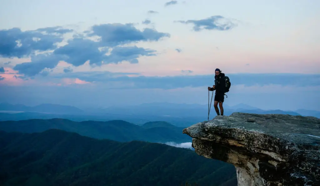  An Appalachian Trail Thru-Hiker stands atop McAfee Knob at sunset in central Virginia