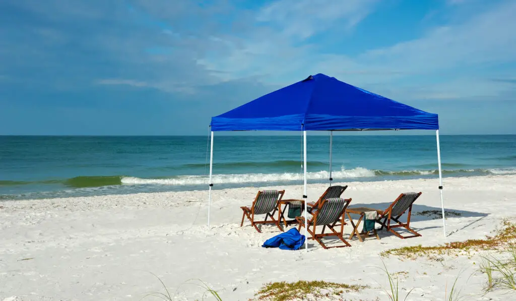 Canopy tent. with lounge chairs and table setup on the beach