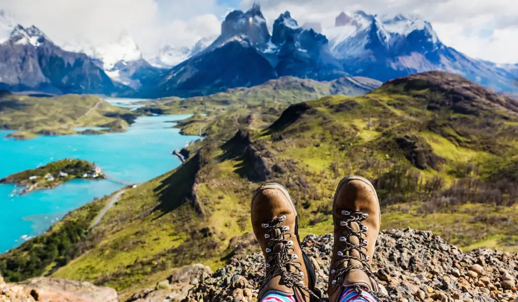 Focus on hiking boots relaxing and enjoying wonderful breathtaking mountain view 