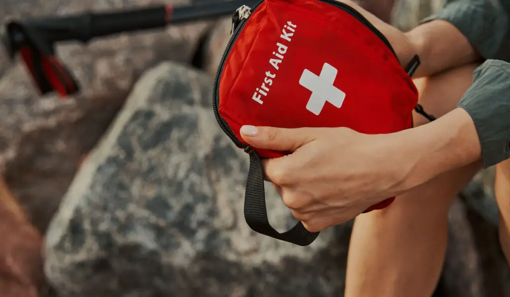 Tourist hiker holding first aid kit bag