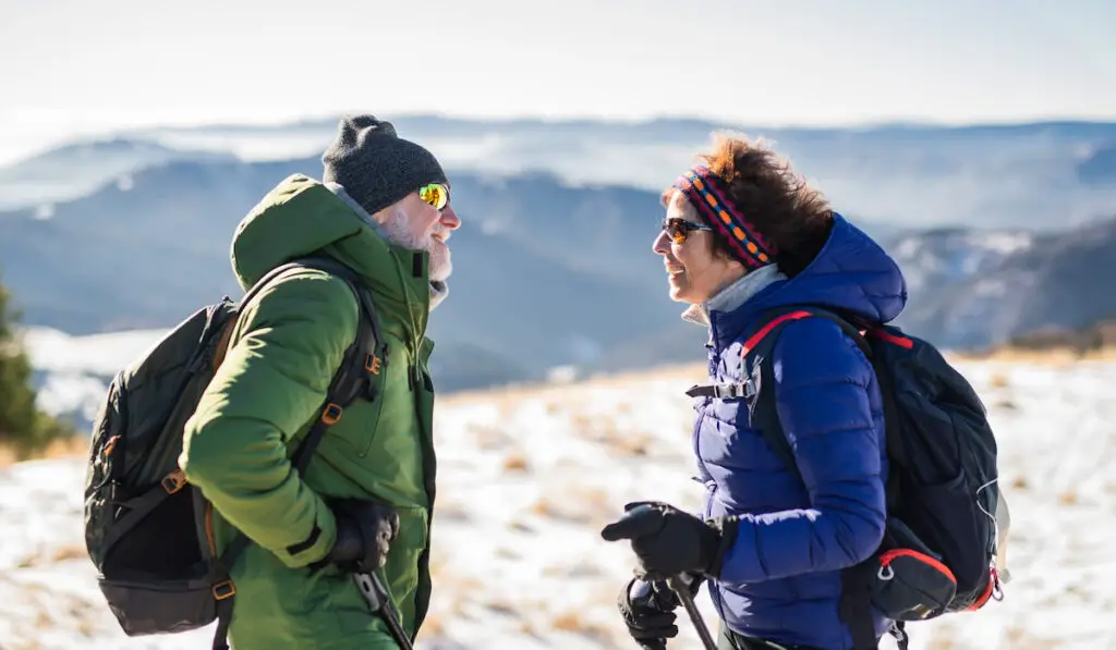 couple hikers talking in snow-covered winter nature