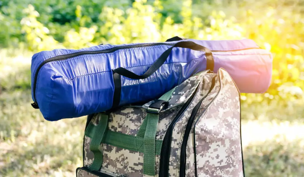 military backpack and blue tent