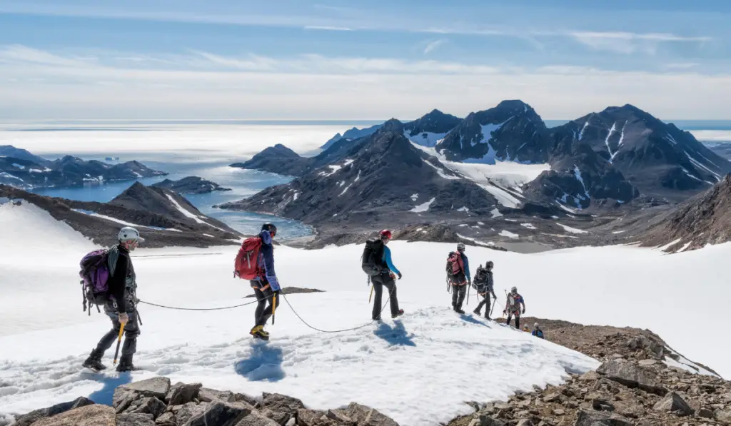 Greenland, Sermersooq, Kulusuk, Schweizerland Alps, group of people walking in snow
