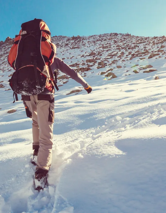 man trekking in the mountains during winter