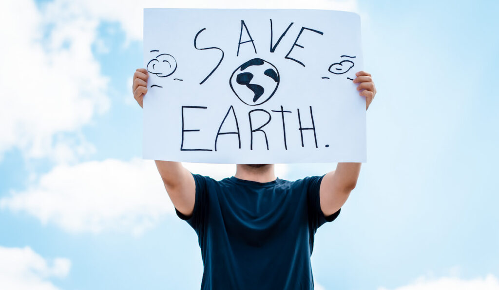 man with a sign that says save earth