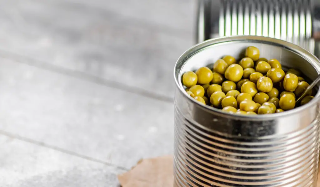 Canned green peas in a tin can on the table
