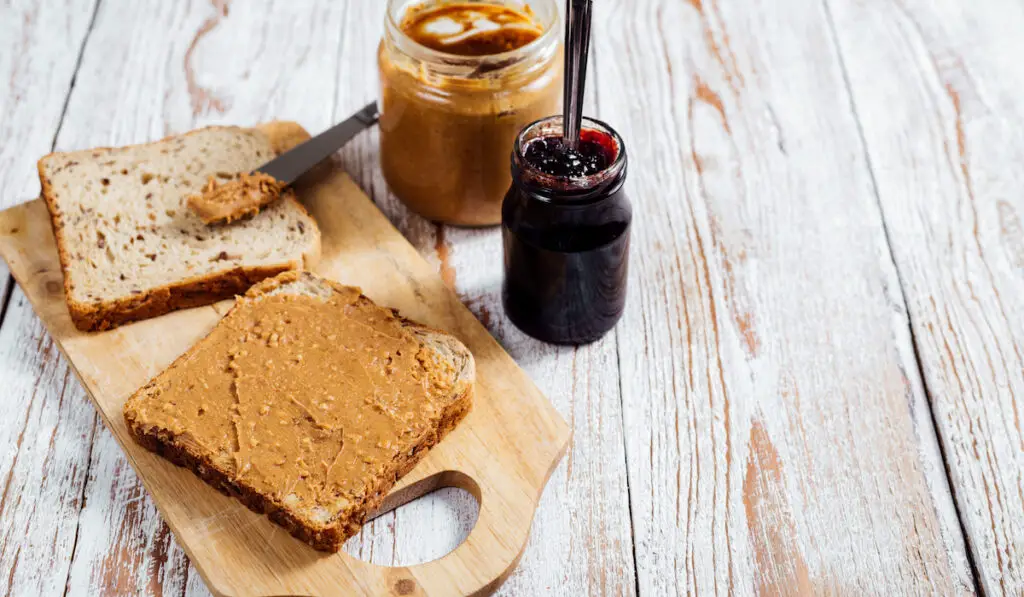 Homemade peanut butter and jelly sandwich on wooden background
